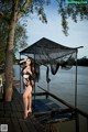 A woman in a black lingerie standing on a dock.