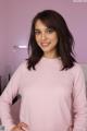 A woman in a pink sweater posing for a picture.