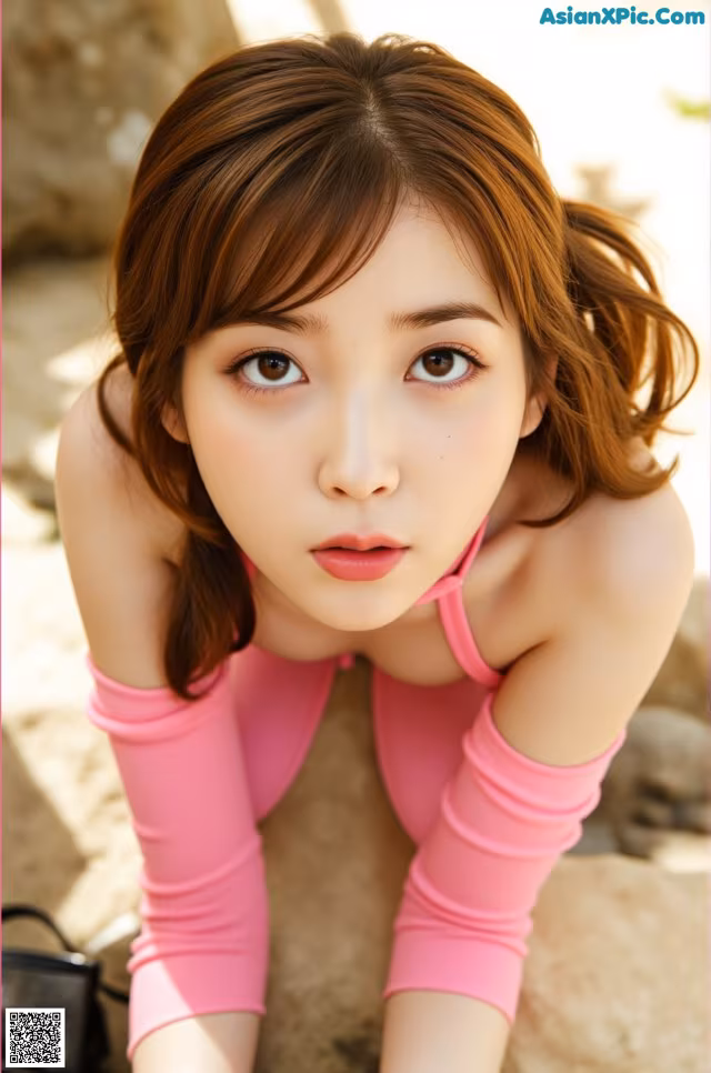 A woman in a pink top and pink gloves posing for a picture.