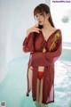 A woman in a red robe standing in a pool.