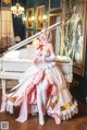 A woman in a white dress sitting on a white piano.